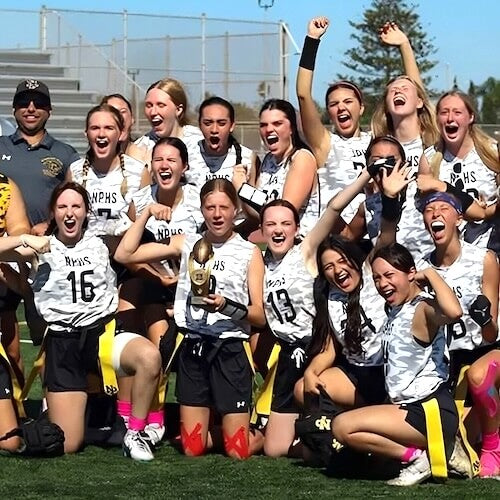 Team of young women celebrating with a trophy on a sports field