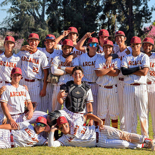 Group of athletes in black shirts with logos, standing together outdoors.