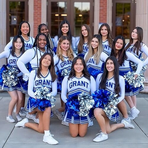 Group of cheerleaders in Grant uniforms posing outdoors.