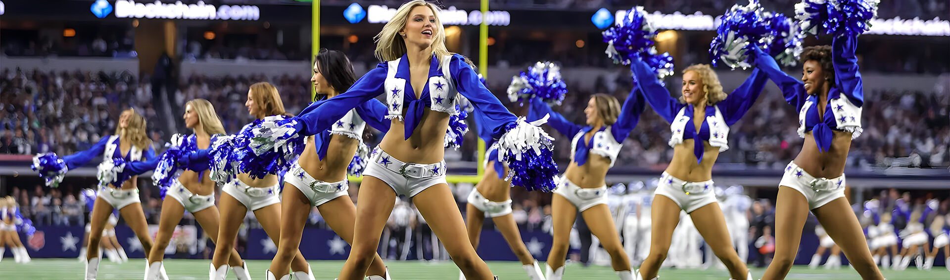A dynamic cheerleading team in blue and white uniforms energizes the crowd as they perform on the football field.