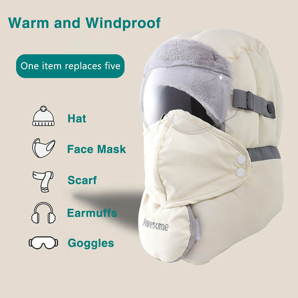 A person wears a beige insulated headgear covering the head, face, neck, and ears with built-in goggles and earmuffs. Text highlights its multifunctionality and windproof features.