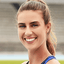 Smiling female athlete standing on a sports field