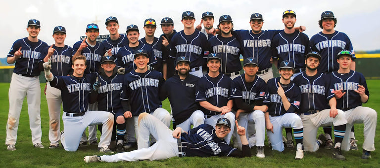 A baseball team of 23 players with blue baseball jerseys posing for a team picture