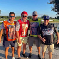 Four men posing together outdoors on a sunny day wear custom sports bibs from Power Rich Sports.